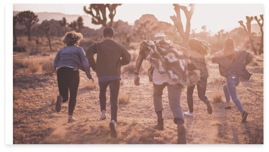 Eine Gruppe von fünf Personen in der Natur, die vorwärtslaufen 