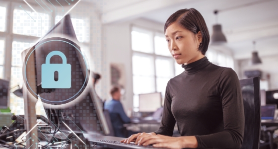 A woman using a computer, chips, and an isometric padlock are overlapping the machine.