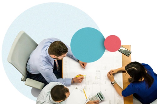 Three people around a desk