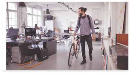 Empleado saliendo de la oficina con una bicicleta