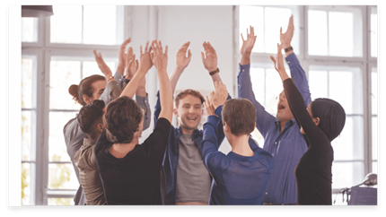 Een groep collega's op kantoor viert iets met de handen in de lucht